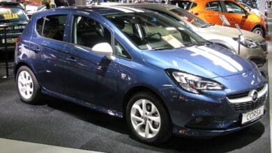 Opel Corsa E 2015 w salonie samochodowym, widok z przodu i boku.