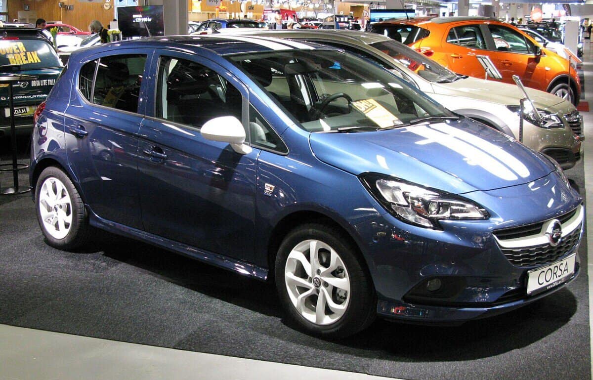 Opel Corsa E 2015 w salonie samochodowym, widok z przodu i boku.