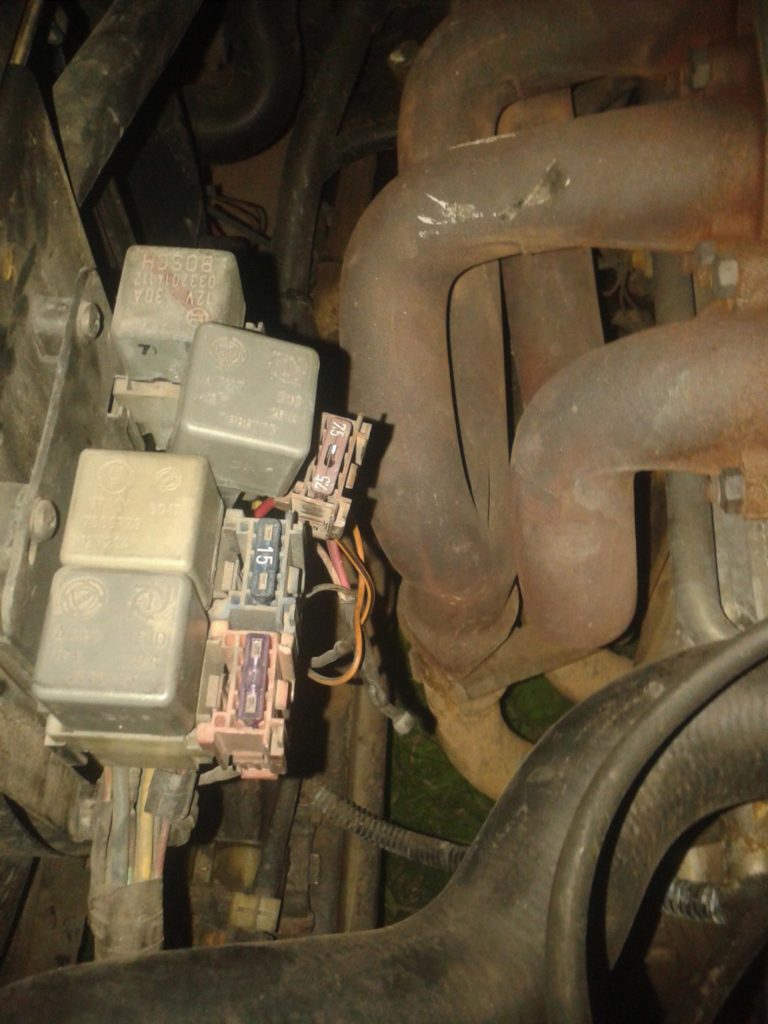 Bezpieczniki w komorze silnika Alfa Romeo 164 Rzeczywiste zdjęcie dodatkowych bezpieczników i przekaźników znajdujących się w komorze silnika Alfy Romeo 164