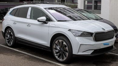 Biały SUV Skoda Enyaq iV na parkingu, widok z boku.